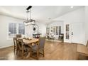 Bright dining room with wood floors, modern light fixture, and neutral decor open to living area at 9970 E Monte Cristo Ave, Scottsdale, AZ 85260