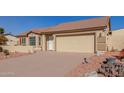 House exterior featuring a two-car garage and neatly kept landscaping at 10334 W Sunbird Dr, Arizona City, AZ 85123