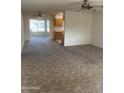 Spacious living room with large windows and ceiling fan at 10630 W Roundelay Cir, Sun City, AZ 85351