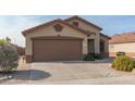 Tan house with a brown garage door and small front yard at 11261 E Quarry Ave, Mesa, AZ 85212