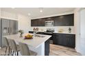 Modern kitchen with island, dark cabinetry, stainless steel appliances, and quartz countertops at 1321 W Inca Dr, Coolidge, AZ 85128