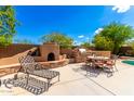 Outdoor kitchen area with a fireplace and seating for dining at 16205 S 7Th St, Phoenix, AZ 85048