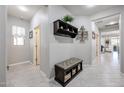 Bright entryway with tiled floors, bench, and coat rack at 17563 W Fairview St, Goodyear, AZ 85338