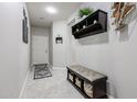 Light and airy entryway with tiled floors and storage bench at 17563 W Fairview St, Goodyear, AZ 85338