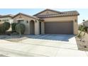 Single story house with a brown garage door and desert landscaping at 17563 W Fairview St, Goodyear, AZ 85338