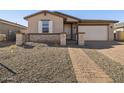 Charming single-story home featuring a block wall, brick pathway, gravel yard and a two car garage at 17761 W Elm St, Goodyear, AZ 85395