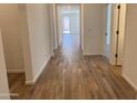 Inviting hallway featuring wood-look tile flooring and neutral paint, offering a seamless flow throughout the home at 20612 N 226Th Dr, Surprise, AZ 85387