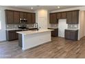 Spacious kitchen with stainless steel appliances, ample cabinetry, an island with quartz countertops and wood-look tile flooring at 20612 N 226Th Dr, Surprise, AZ 85387