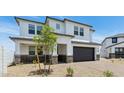 Two story home featuring a two-car garage, desert landscaping, and neutral-colored paint at 2316 W Moody Trl, Phoenix, AZ 85041