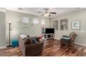 Living room with hardwood floors, brown couch, recliner, and a TV at 26015 N 53Rd Dr, Phoenix, AZ 85083