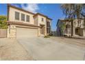 Two-story house with tan exterior, stone accents, and a two-car garage at 28396 N Tourmaline Dr, San Tan Valley, AZ 85143