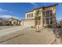 Two-story house with tan exterior, stone accents, and a two-car garage at 28396 N Tourmaline Dr, San Tan Valley, AZ 85143