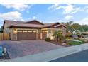 Two-car garage and inviting facade with stone accents and well-manicured lawn at 3560 E Ironside Ln, Gilbert, AZ 85298