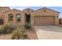 Tan one-story house with a two-car garage and drought-tolerant landscaping at 40861 W Little Dr, Maricopa, AZ 85138