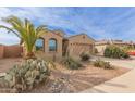 One-story house with palm trees, cacti, and a rock driveway at 40861 W Little Dr, Maricopa, AZ 85138