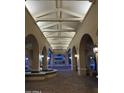 Elegant entryway with arched walkways, fountain, and a brick paved floor at 4200 N Miller Rd # 112, Scottsdale, AZ 85251