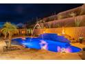 Stunning nighttime view of a resort-style pool with fountains and fire features at 10110 W Redbird Rd, Peoria, AZ 85383