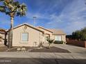 Tan house with a two-car garage and desert landscaping at 18803 N 16Th Pl, Phoenix, AZ 85024