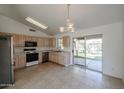 Kitchen with light wood cabinets, stainless steel appliances, and access to the backyard at 2828 E Blackhawk Dr, Phoenix, AZ 85050