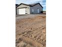 Rear exterior view of a house with a gray exterior and a large lot at 31540 W Maricopa St, Buckeye, AZ 85326