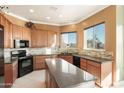 Island kitchen with granite countertops and wood cabinetry at 31617 N 168Th St, Rio Verde, AZ 85263