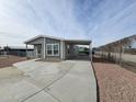 Manufactured home with covered parking and a gravel yard at 318 S Ellsworth Rd, Mesa, AZ 85208