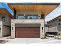 Contemporary home featuring a stone accent wall, sleek wood garage door, and a minimalist design at 4575 N Phoenician Blvd # 2, Scottsdale, AZ 85251