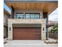 Contemporary home with a stone facade, upper balcony, wood garage door with modern black trim at 4575 N Phoenician Blvd # 4, Scottsdale, AZ 85251
