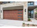Modern wood garage door with stone surround and sidelight window, next to desert landscaping at 4575 N Phoenician Blvd # 4, Scottsdale, AZ 85251