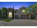 Elegant two-story home exterior, beautifully lit at night at 5019 E Lucia Dr, Cave Creek, AZ 85331