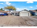 Front view of a single story home with a tree and rock landscaping at 5415 N 79Th Dr, Glendale, AZ 85303