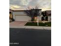 Single-story stucco home features a two-car garage, desert landscaping, and a well-maintained front lawn at 8243 E Cortez Dr, Scottsdale, AZ 85260