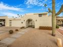 Mid-century modern home with a landscaped front yard and gated entry at 8626 E Mackenzie Dr, Scottsdale, AZ 85251