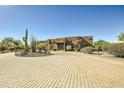 Front view of a beautiful Southwestern style home with a circular driveway at 9135 E Buckskin Trl, Scottsdale, AZ 85255