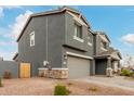 Gray two-story home with stone accents and a two-car garage. Side yard view at 9354 E Sector Dr, Mesa, AZ 85212