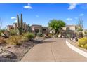 Expansive desert-landscaped property with winding driveway, and attached garage at 10420 E Morning Vista Ln, Scottsdale, AZ 85262