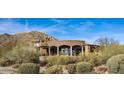 Gorgeous rear exterior featuring a covered patio with grand columns and desert views at 10922 E Purple Aster Way, Scottsdale, AZ 85262