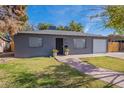 Charming gray house with a brick walkway, and a spacious lawn at 12023 N 113Th Ave, Youngtown, AZ 85363