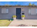 Gray house with black front door and two matching planters at 12023 N 113Th Ave, Youngtown, AZ 85363