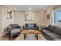 Bright living room featuring hardwood floors and comfy gray sofas at 1637 N Bridalwreath St, Tempe, AZ 85288