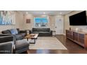 Spacious living room with dark hardwood floors, gray sofas and a large window at 1637 N Bridalwreath St, Tempe, AZ 85288