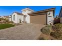 Front view of a house with a brown garage door and artificial turf at 17184 W Mountainair St, Surprise, AZ 85388