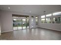 Bright living room with wood floors, large windows, and sliding glass doors leading to backyard at 1932 W Rowel Rd, Phoenix, AZ 85085