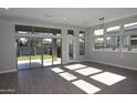 Bright and airy living room with hardwood floors, many windows providing natural light, and a sliding door to the outside at 1932 W Rowel Rd, Phoenix, AZ 85085