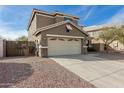 Two-story house with beige exterior, a large garage, and a well-maintained front yard at 224 S 151St Ave, Goodyear, AZ 85338