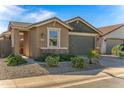 Tan house with a green garage door and desert landscaping at 41233 W Carlisle Ln, Maricopa, AZ 85138