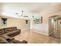 Bright living room, tile floors, and a large flat-screen TV at 45513 W Sky Ln, Maricopa, AZ 85139
