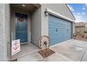 Front entrance with blue door, decorative wagon wheel, and welcome sign at 4887 N 179Th Dr, Goodyear, AZ 85395