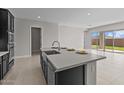 Modern kitchen features stainless steel appliances, black cabinets and an island with a sink and countertop seating at 5525 N 193Rd Dr, Litchfield Park, AZ 85340