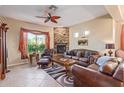 Living room with stone fireplace, leather furniture, and a ceiling fan at 6202 E Mckellips Rd # 42, Mesa, AZ 85215